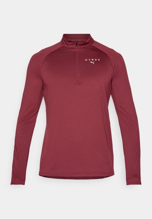 Bordowa, długorękawowa koszulka sportowa z wysokim kołnierzem, zamek błyskawiczny na ćwierć długości z przodu oraz białym logo 'HYROX' na piersi, wykonana z elastycznego materiału.