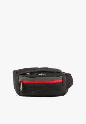 Borsetta nera in tessuto con zip rossa, logo a rilievo ed emblemma metallico sul davanti. Forma rettangolare compatta con superficie liscia.