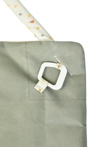 Green bag made of textured material with a patterned handle, featuring a white rectangular hardware attachment. Simple and functional design.