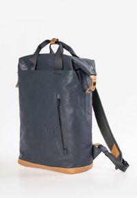 Navy Leder-Rucksack mit Rolltop-Design, ausgestattet mit hellbraunen Akzenten, einer Front-Reißverschlusstasche und gepolsterten Schultergurten mit Mesh.