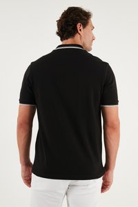 Čierna polo košeľa s krátkymi rukávmi, s bielymi pruhmi na golieri a manžetách. Mäkká textúra, klasický strih a minimalistický dizajn.