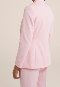Helles rosa Blazer mit langen Ärmeln und taillierter Passform. Glattes Material mit einem Ein-Knopf-Verschluss und dezenten Schulterpolstern.