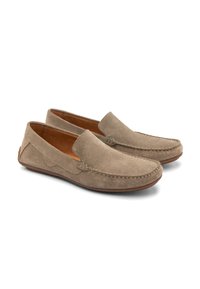 Mocasini din piele de căprioară de culoare bej deschis, cu o textură netedă, talpă maro în contrast. Au broderii decorative și un detaliu discret în formă de val pe laterale.