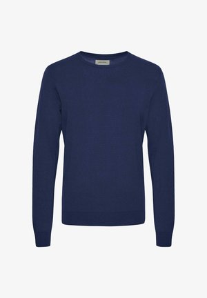 Tummansininen pitkähihainen neulepaita pehmeästä, tekstuuriltaan mielenkiintoisesta kankaasta, pyöreällä kaula-aukolla ja resorikäsivarsilla sekä -helmalla. Minimalistinen muotoilu, ei kuvioita.