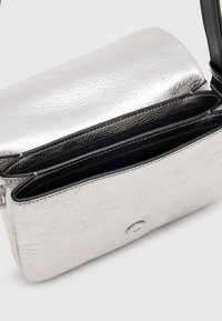 Silberne metallische Umhängetasche aus strukturiertem Leder, zwei Fächer und Druckverschluss. Verstellbarer schwarzer Riemen.