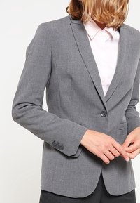 Šedý péřový blazer z texturované tkaniny, s klopovým límcem, zapínáním na jeden knoflík a manžetami na tři knoflíky.