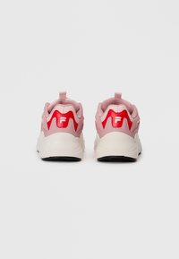 Une paire de baskets de sport roses et rouges avec des semelles épaisses blanches, présentées de dos sur un fond blanc uni.