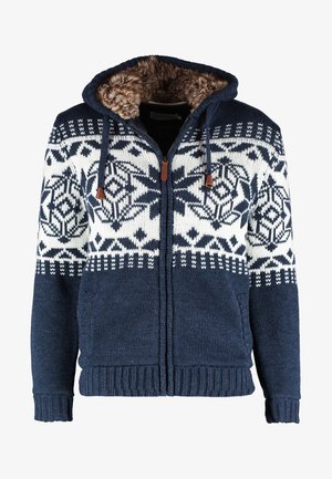 Tamnoplava zip-up dukserica s bijelim geometrijskim uzorcima, debele teksture, s umjetnim krznom unutar kapuljače i podesivim vezicama.