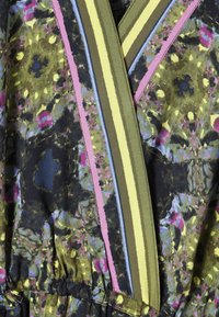 Gros plan sur un tissu avec un motif floral abstrait en vert, jaune, rose et bleu, comportant des bandes rayées verticales en olive, jaune, rose et bleu.