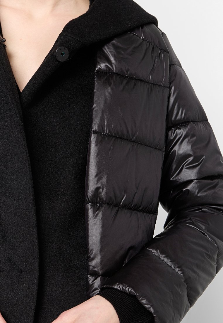 Czarna kurtka puchowa z błyszczącymi, pikowanymi panelami i teksturowanym kołnierzem. Posiada zapięcie na guziki i dopasowany krój.