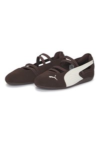 Καφέ παπούτσια από σουέτ με λευκές λεπτομέρειες, με σταυρωτούς ελαστικούς ιμάντες και ανάγλυφη λαστιχένια σόλα. Λογότυπο Puma στο πλάι.