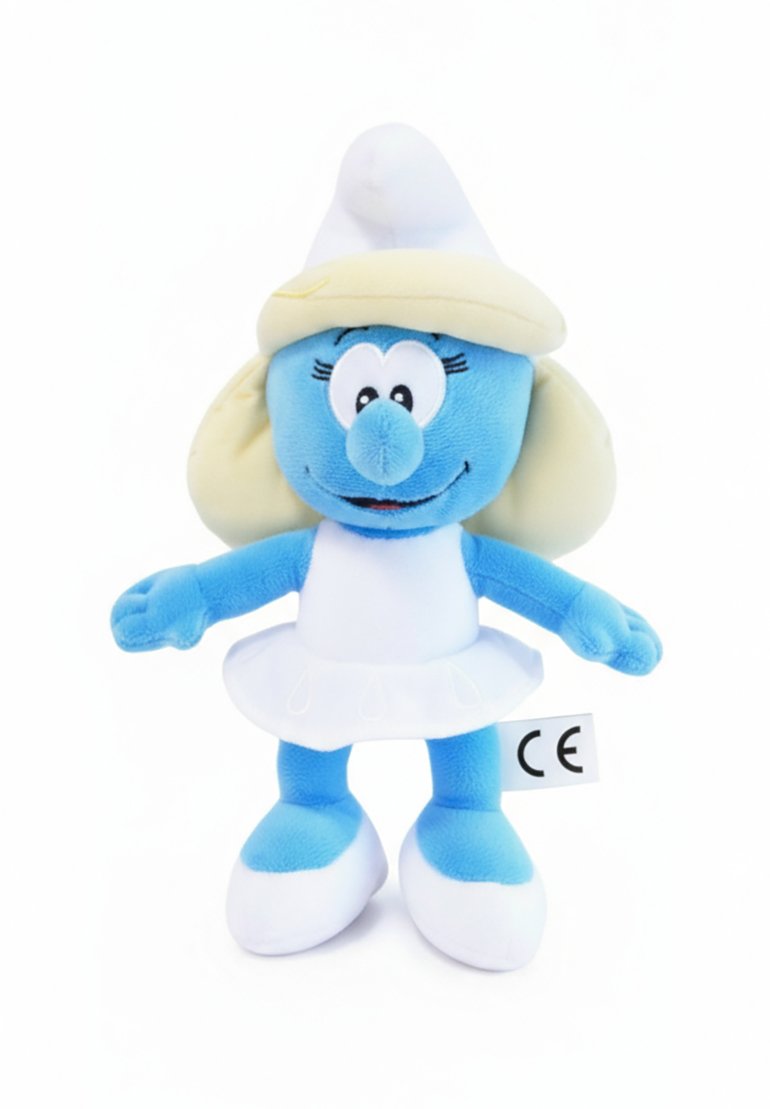 Blauw pluche speelgoed met een ronde kop, grote ogen, gele haren onder een witte hoed, en een witte jurk met een gerimpelde onderkant en witte schoenen.