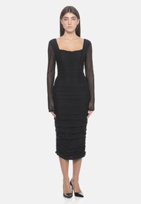 Robe noire avec de longues manches transparentes, décolleté carré et texture froncée. Silhouette ajustée se terminant au milieu du mollet avec des détails plissés.