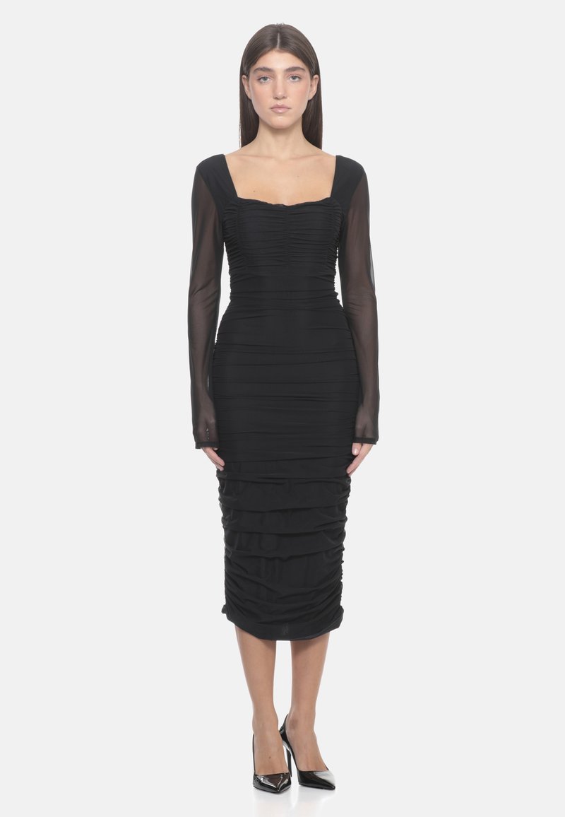 Robe noire avec de longues manches transparentes, décolleté carré et texture froncée. Silhouette ajustée se terminant au milieu du mollet avec des détails plissés.