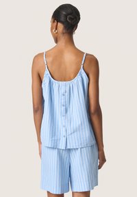 Haut sans manches rayé bleu clair avec un col froncé et un détail de bouton au dos, associé à un short rayé assorti.