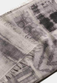 Sciarpa grigia e nera con un motivo a fantasia e una texture morbida, caratterizzata da bordi frangiati e un mix di design astratti chiari e scuri.