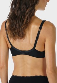 Sort bh med justerbare stropper, blondeaccent og hægtekrogslukning bagpå. Glat stof med sømløst design.