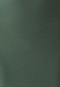 Temno zeleno blago z gladko, mat površino; brez vidnih vzorcev ali detajlov strojne opreme. Material se zdi lahek in fleksibilen.