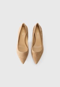 Par de sapatos de salto alto em camurça bege com bico apontado e marca "Michael Kors" por dentro, colocados lado a lado sobre um fundo branco.