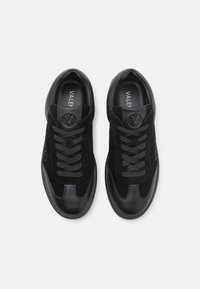 Sneaker nere realizzate con un mix di materiali scamosciati e in pelle, con punta rotonda, lacci semplici e un dettaglio del logo sulla linguetta.