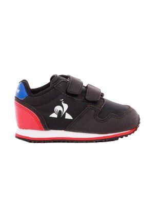 Zapatilla deportiva infantil negra con talón rojo, cuello azul, suela blanca, doble tira de velcro y logotipo blanco de gallo en el lateral.