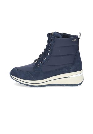 Baskets montantes bleu marine en matériaux lisses et en daim, avec une semelle blanche, des œillets en métal et une languette au talon.