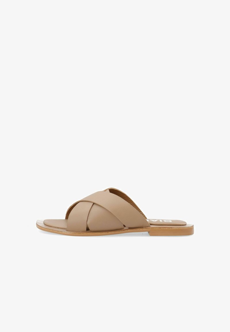 Infradito in pelle beige con design a fascette incrociate, suola piatta e accenti marrone chiaro. Texture liscia con uno stile semplice e minimalista.