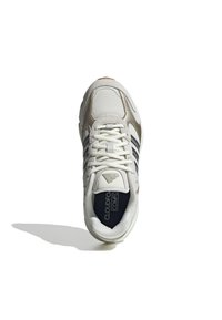 Białe i beżowe buty sportowe z siateczkowych i zamszowych materiałów, z trzema granatowymi paskami, fakturowanymi akcentami oraz amortyzowaną podeszwą.