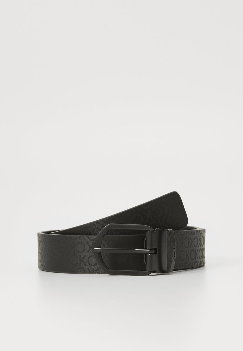Cintura nera con motivo logo impresso, dotata di una fibbia rettangolare in metallo nero e una texture liscia. Lunghezza regolabile e design semplice.