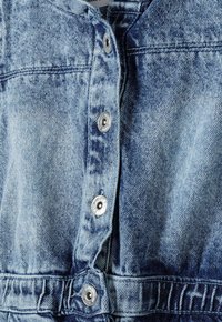 Veste en denim en tissu bleu clair, fermeture à boutons classique et léger délavage. Comprend des boutons en métal argenté et des détails brodés.