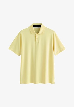 Jasnożółta koszulka polo z krótkim rękawem, kołnierzykiem i plisą z dwoma guzikami, prezentowana na białym tle.