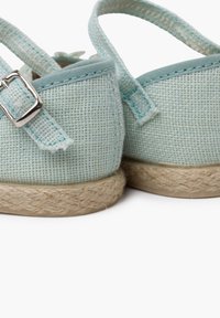 Jasnoniebieskie buty z plecionego materiału z jucianą podeszwą w stylu espadryli. Posiadają pasek z metalowym zapięciem oraz subtelne detale szycia.