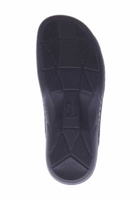 Schwarze Schuhsohle mit einer strukturierten Oberfläche, ausgestattet mit einem geometrischen Profilmuster für besseren Grip und einem in der Mitte eingeprägten Logo.