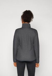 Kullgrå fleecejakke med høy krage, teksturert finish, tettsittende design og flate sømmer. Ingen synlig merkevare eller beslag.
