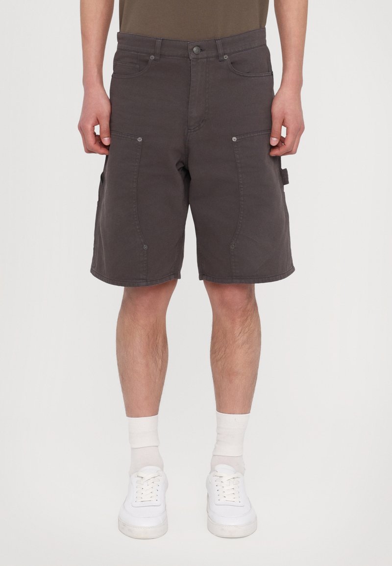 Gray cargo shorts made of cotton, featuring multiple pockets, a relaxed fit, and a straight cut, paired with white sneakers and socks.