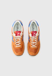 Orange sneaker with blue accents, suede and mesh materials, white laces, black sole, and branded tongue label. Design features a classic shape.