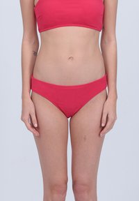 Ensemble de bikini rouge comprenant un top bandeau et un bas taille basse. Le tissu semble lisse avec une finition mate et sans motifs visibles.