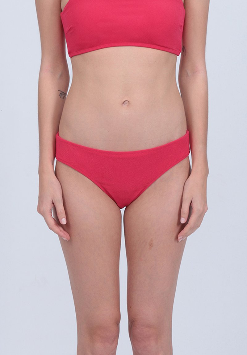 Ensemble de bikini rouge comprenant un top bandeau et un bas taille basse. Le tissu semble lisse avec une finition mate et sans motifs visibles.