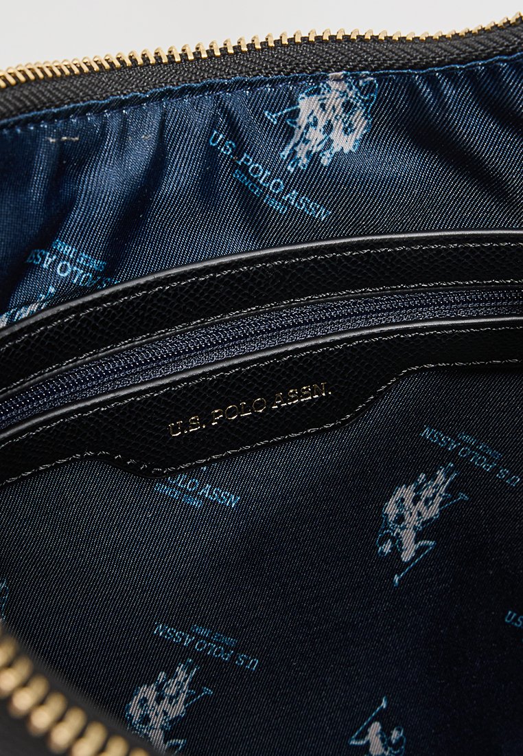 Schwarze Reißverschluss-Zubehörtasche mit strukturiertem Äußeren, goldfarbigem Reißverschluss und blauer Innenauskleidung mit wiederholten Mustern des U.S. Polo Assn. Logos.
