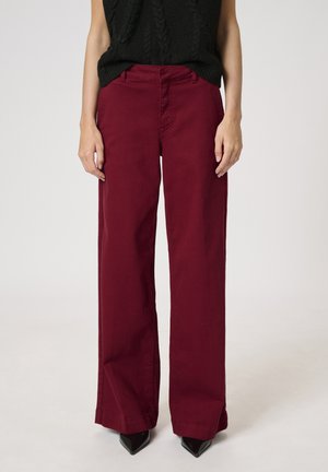 Pantaloni largi burgundy din bumbac, cu talie înaltă și un design tradițional al buzunarelor. Finalizați cu o textură netedă.