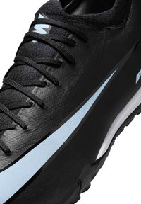 Zapatilla deportiva negra con parte superior sintética texturizada, cordones negros planos, acentos en azul claro y una suela resistente para tracción.
