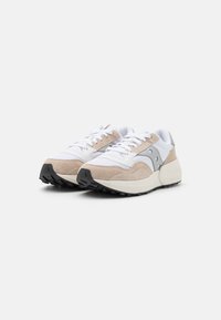 Sneaker beige in suede e mesh bianco con suola nera e dettagli grigi. Presentano lacci rotondi e una suola intermedia imbottita per il comfort.