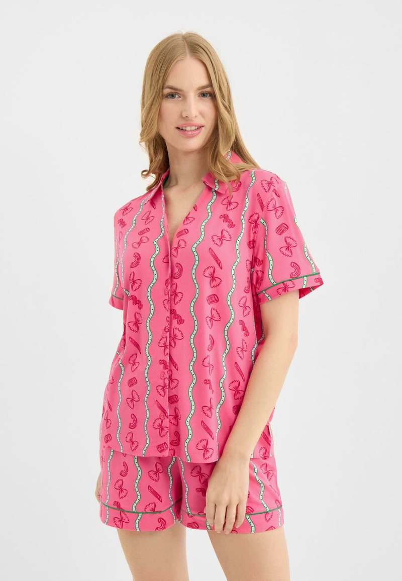 Conjunto de camisa de manga corta y pantalones cortos en color rosa con un patrón divertido de diversas formas. Tela lisa con detalles en azul claro contrastante.