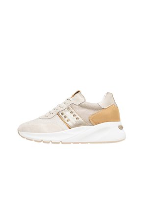 Beige sneaker made from suede and mesh, featuring gold accents, textured surface, and a chunky white sole. Includes stud detailing on the side.