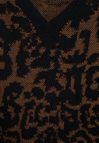 Czarny sweter z dekoltem w serek, wzorzysty w zwierzęcy motyw na brązowym, teksturowanym tle, podkreślający połączenie materiałów i skomplikowane detale.