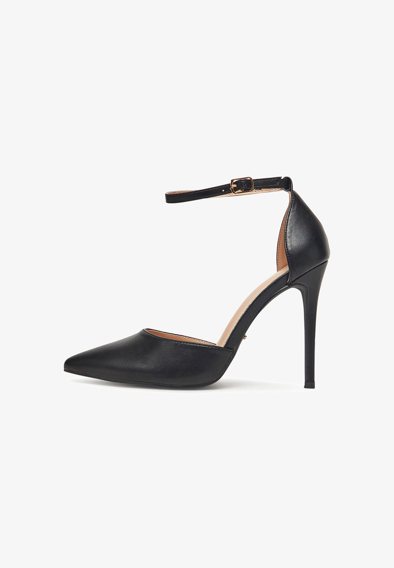 Cizme negre cu toc stiletto ascuțit, cu curea la gleznă și cataramă aurie, spate închis, și finisaj din piele netedă.