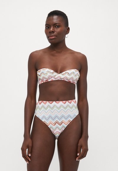 Bikini set in zigzag pattern, featuring a strapless top and high-waisted bottom. Colors include white, red, blue, and green accents.