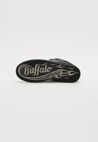 Sola di sneaker nera con un motivo testurizzato, caratterizzata da un design a fiamma e dal logo "Buffalo" in un colore contrastante. Materiale in gomma resistente.