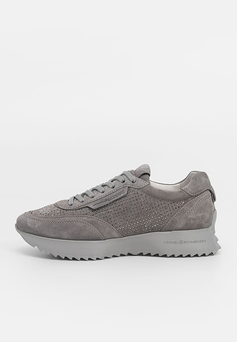 Graue Wildleder-Sneaker mit durchbrochenem Design, runder Spitze, flachem Schnürverschluss und einer klobigen Gummisohle mit gezahntem Rand. Markenlogo an der Seite.