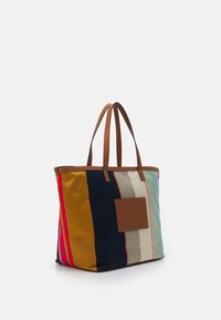 Canvas tote bag with multicolored vertical stripes. Features brown leather accents and handles. Large, open top with a flat base.